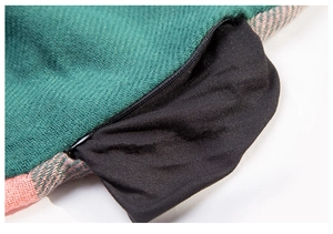 Close-up of green and pink woven scarf featuring a functional black zippered pocket
