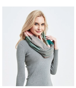 Detail of knitted infinity scarf featuring pink, grey and green patchwork and zipper pocket