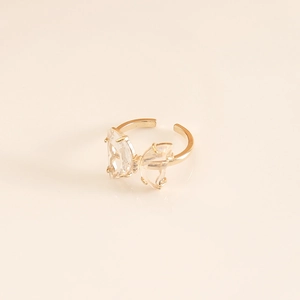 Detailed macro view of an adjustable gold butterfly ring with inlaid clear gemstones