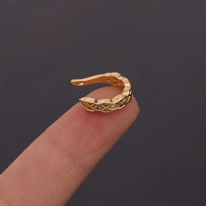Detail view of gold hollow U-shaped ear cuff with sparkling zircon inlay on a finger