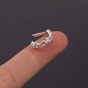 U-shaped silver star ear cuff with zircon crystals shown on a fingertip for size
