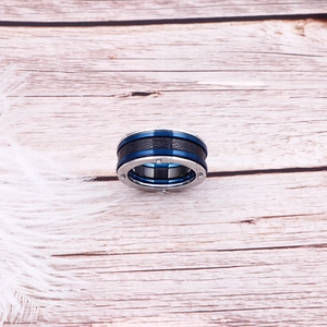Detail showing blue and silver stainless steel ring with black carbon fiber inlay texture