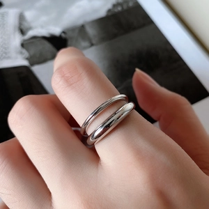 Detailed view of minimalist double-layered silver ring worn on model's hand