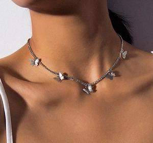 Dettaglio della collana in argento con ciondoli a farfalla indossata su un modello