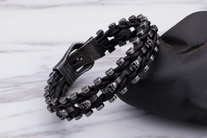 Macro view of woven black leather bracelet with retro silver skull and buckle