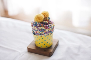 Close-up of fluffy coral fleece socks folded like a colorful cupcake with pom-poms