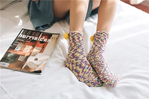 Thick coral fleece socks with colorful texture and yellow pompom detail for home wear