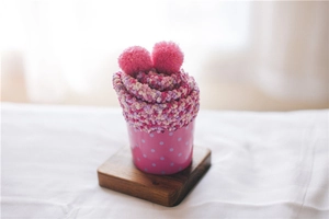 Close-up of fluffy pink and purple coral fleece cake socks in creative gift packaging