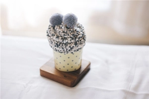 Close-up of cozy coral fleece cake socks in cupcake gift packaging on wooden base
