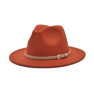 Close-up of caramel wool fedora hat featuring a thin khaki leather band and gold buckle