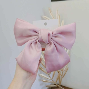Detail of pink silk texture bow hair clip with Korean style spring fastener design