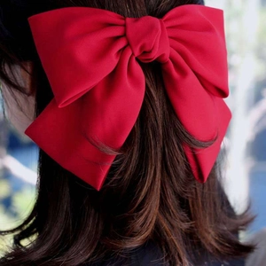 Detailed back view of a large wine red bow hair clip with velvet texture on hair