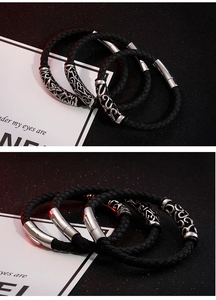 Details von schwarzen geflochtenen Lederarmbändern mit gravierten Metallröhren