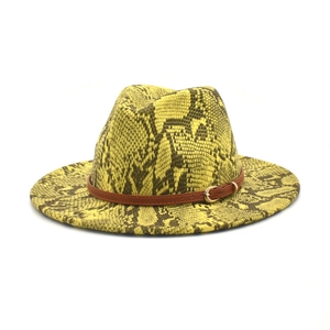 Detail of yellow fedora hat with black snake skin pattern and brown leather buckle strap