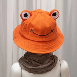 Close-up of orange frog bucket hat with 3D eyes and smiling embroidery for kids