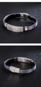 Dettaglio del bracciale in fibra grigia intrecciata con incisione XOXO e chiusura in acciaio