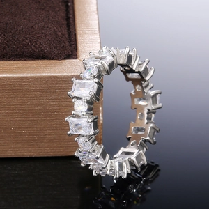 Détail macro d'une bague éternité en zircon carré sur un coffret en velours brun