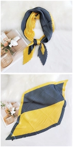 Detail of pleated silk scarf showing contrast yellow and grey blocks with organ textures