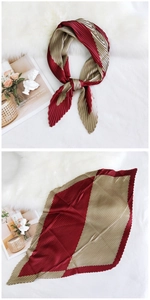 Detail of pleated silk-like square scarf in reddish-brown with elegant accordion folds