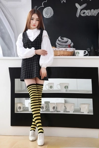 Detail of black and yellow striped over-knee high socks worn with a classic Japanese outfit
