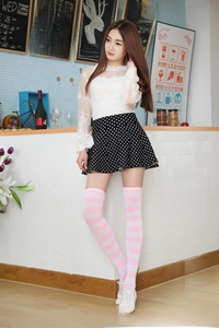 Detail of pink and white striped over-knee high socks in a stylish cafe setting