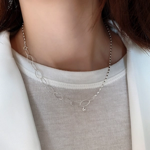 Detail of 925 sterling silver olive bead necklace on neck with asymmetrical chain design