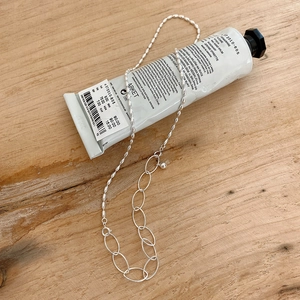 Close-up of 925 sterling silver necklace with olive beads and mixed chain links