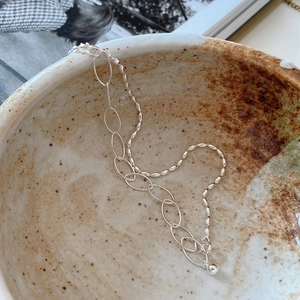 Detail view of 925 silver beaded chain bracelet placed in a minimalist ceramic bowl