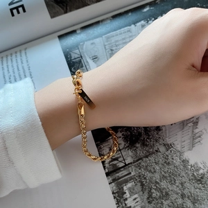 Detailed view of a gold plated 925 sterling silver twisted rope chain bracelet on wrist
