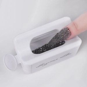 Macro view of white plastic nail dipping powder recycling tray with steel micro beads