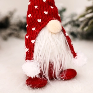 Christmas forest gnome with red knitted heart hat and long white beard on soft surface