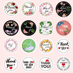 Macro view of 16 various round floral thank you stickers for packaging and decor
