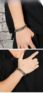 Macro detail of men's titanium steel cuban link bracelet featuring a pray engraved cross