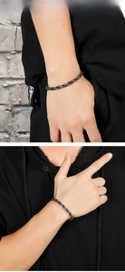 Detail eines schwarzen Herren-Armbands aus Edelstahl mit Flechtstruktur am Handgelenk