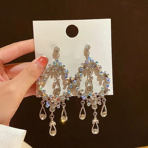 Detailed macro view of vintage hollow teardrop earrings with crystals and silver tassels