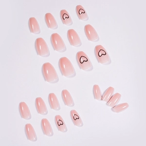 Short ballet nude pink gradient press-on nails with minimalist black heart patterns