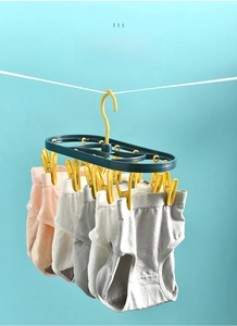 Detail of multi-clip laundry drying rack with 12 windproof yellow pins on blue frame