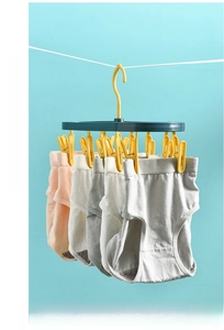 Detail of 12-clip plastic drying rack for socks and underwear hanging on a clothesline