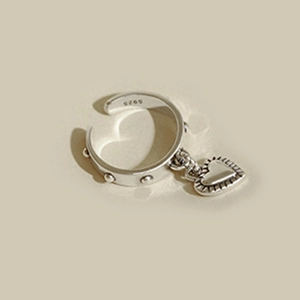 Detail of silver S925 open ring with heart pendant and studded rivet texture on band
