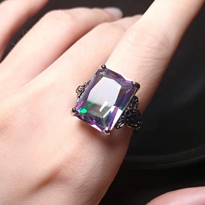 Detailed macro view of rectangle rainbow mystic topaz ring with intricate filigree metalwork