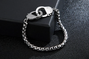 Detailed macro shot of silver stainless steel handcuffs clasp on a chunky box chain
