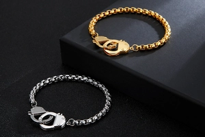 Detail of interlocking handcuff clasp on gold and silver stainless steel box chain bracelets