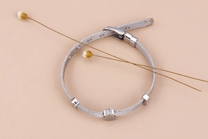 Detail eines verstellbaren silbernen Mesh-Armbands mit süßem Bären-Anhänger-Charme