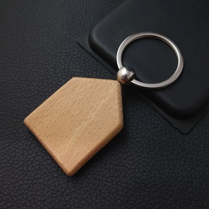Macro shot of house-shaped beech wood keychain with stainless steel ring on leather