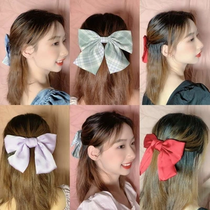 Detail shots of various colorful oversized fabric bow hair clips on model hair