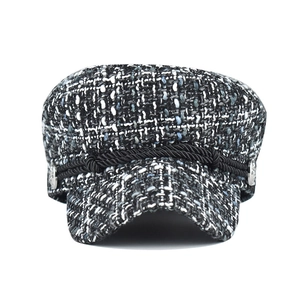 Close-up of mixed tweed wool newsboy cap with black rope and silver buttons