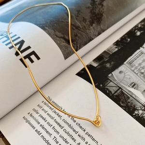 Elegant gold snake chain necklace showcased on a minimalist lifestyle fashion magazine