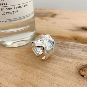 Macro detail of 925 sterling silver ring featuring unique lava texture on wood background