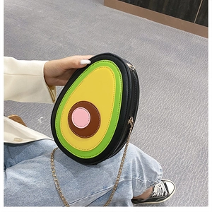 Detail of creative avocado-shaped PU leather crossbody bag with golden chain strap