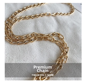 Detailed macro view of the premium golden metal chain strap on white fabric background